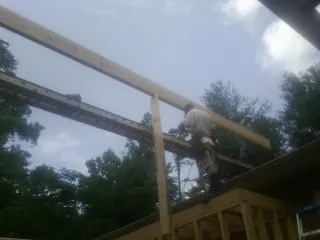 Carpenter setting a ridge beam over a new addition frame — Ice Dam Removal by Roofing Brothers in Hume